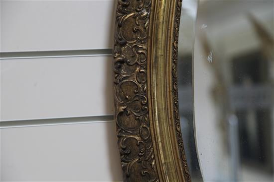 A large Victorian oval gilt wall mirror, 4ft 7in.